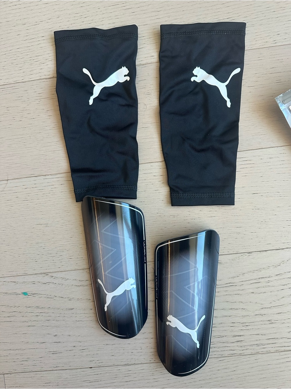 Puma Black Shin Guards with White Logos and Black Sleeves